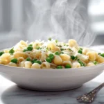 Ditalini pasta recipe served in a warm bowl with peas and Parmesan.