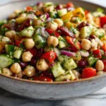 Dense bean salad with chickpeas, vegetables, and herbs in a bright kitchen