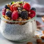 Protein chia pudding with berries and granola in a glass jar