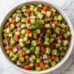 Pickle de gallo served in a white bowl with fresh vegetables